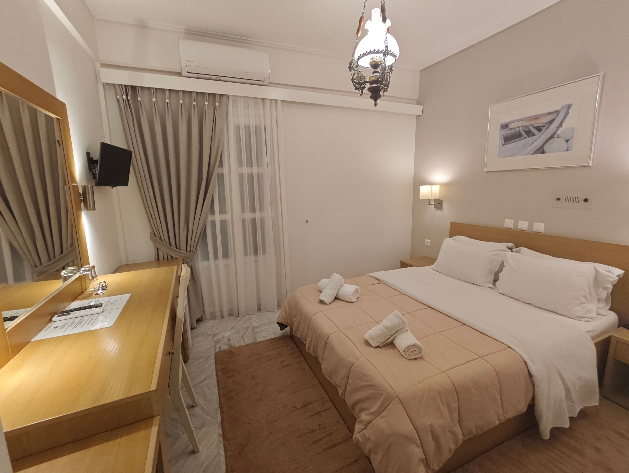 Newly renovated double room with a wooden headboard and a framed painting of a fishing boat